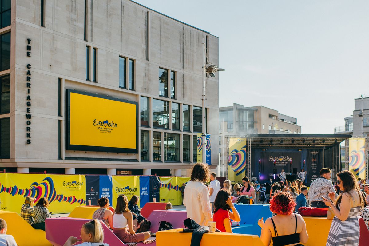 Leeds Big Screen displaying Eurovision branding as people gather in Millennium Square for outdoor event