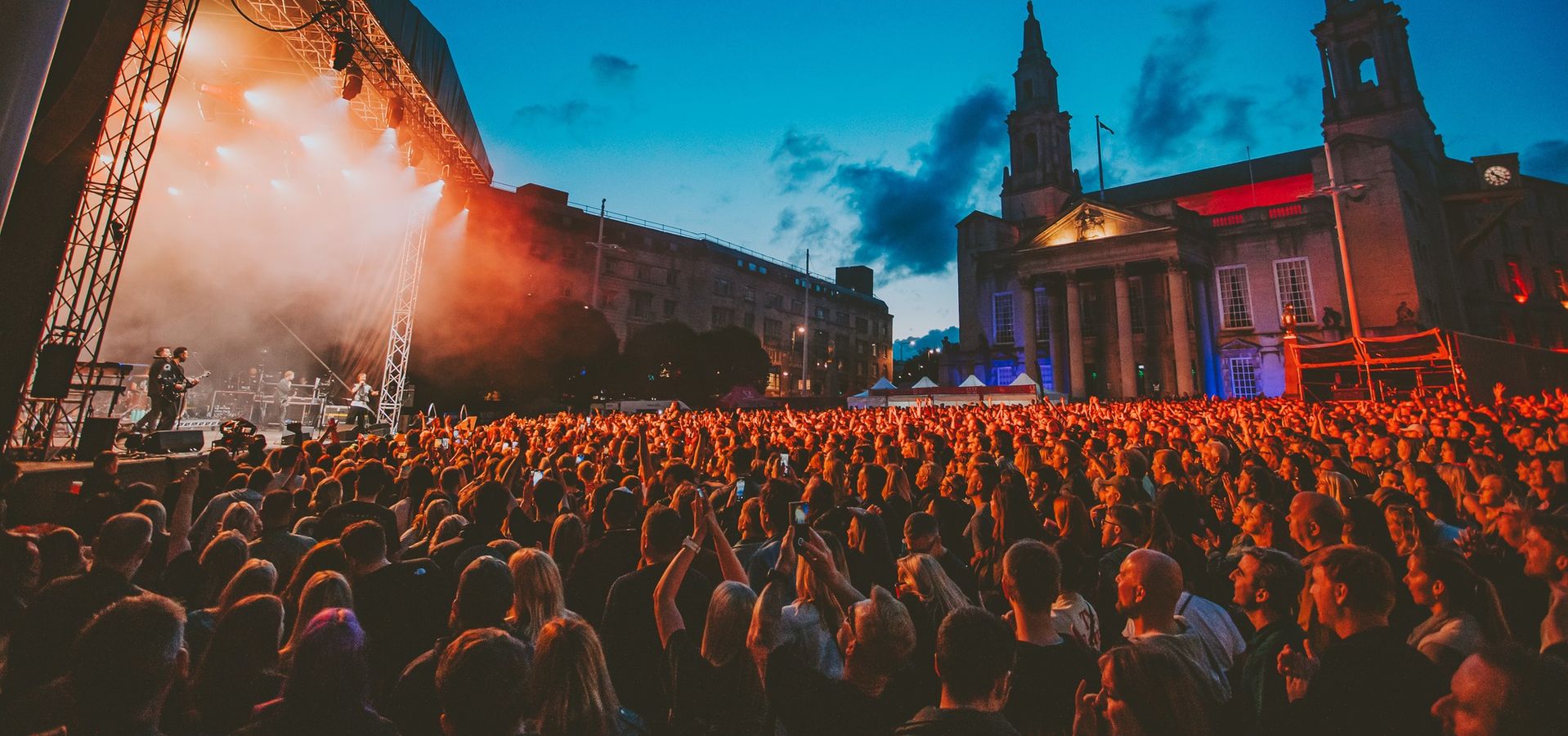 the stage and the civic hall on either side with the crowd enjoying a concert