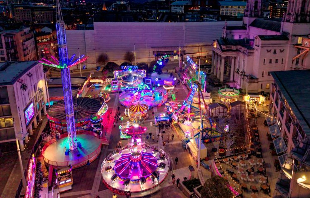 Valentine's Fair rides lit up at night on the square