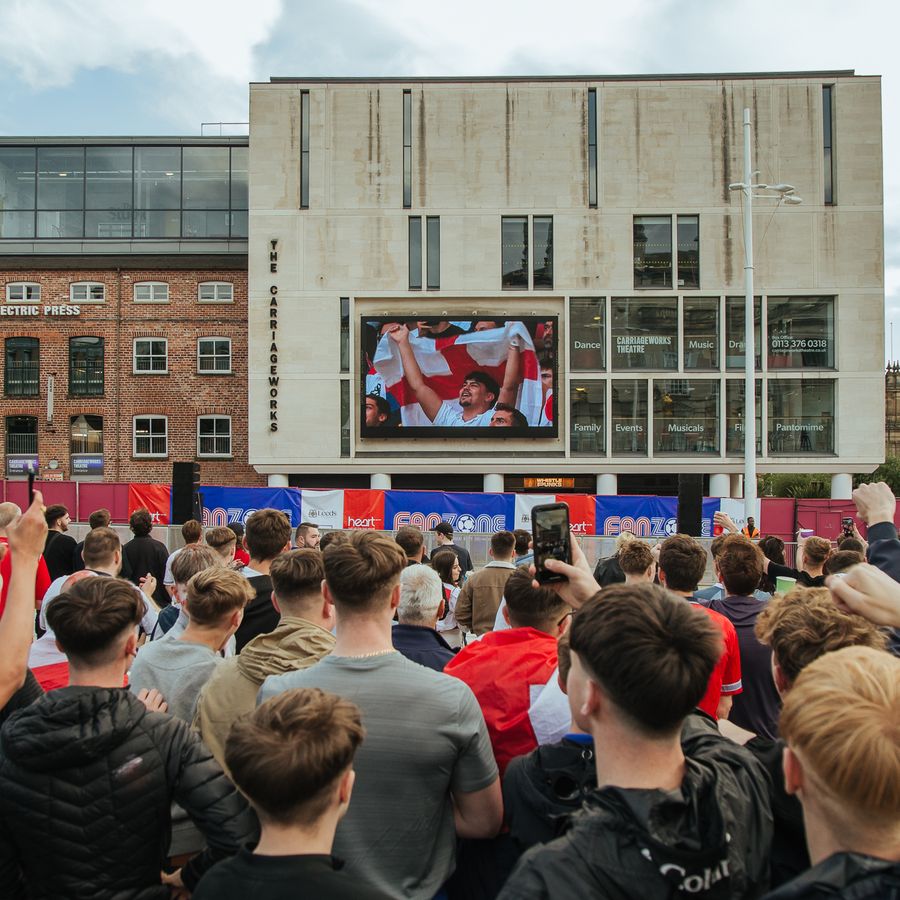 Crowd of football supporters watching a game on the big screen