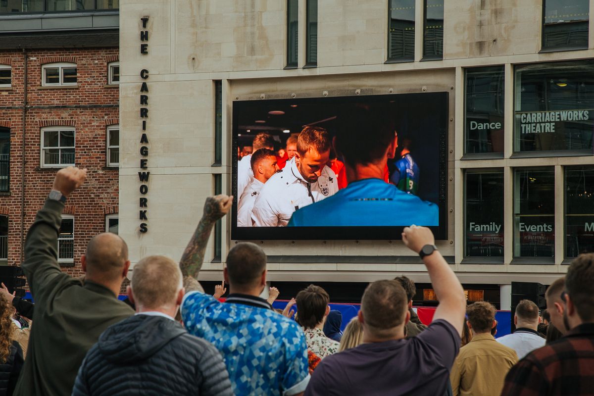 Football supporters watching a live game on the screen