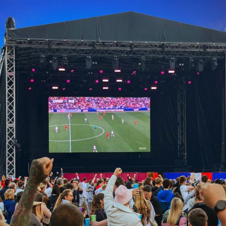 Football game broadcast on a stage screen