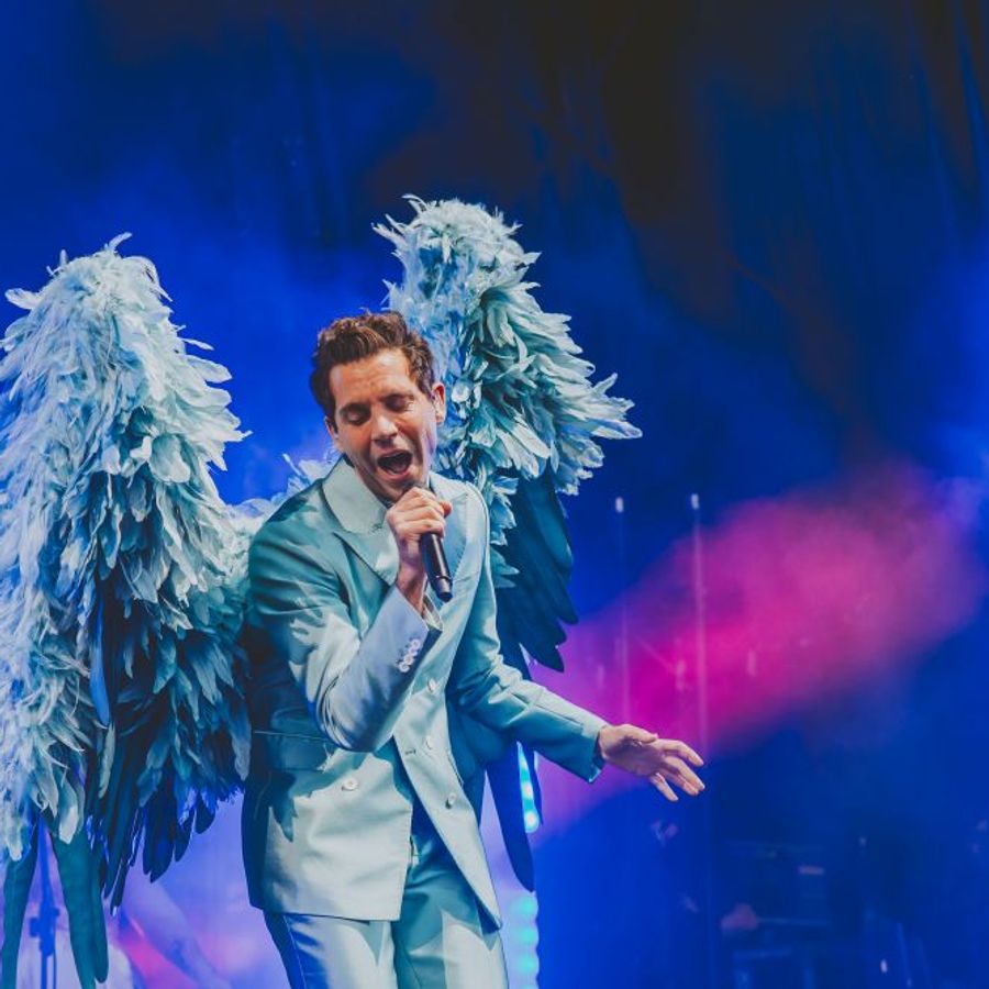 Mika performing with large feathered wings on stage at Millennium Square Leeds during the 2025 Summer Series