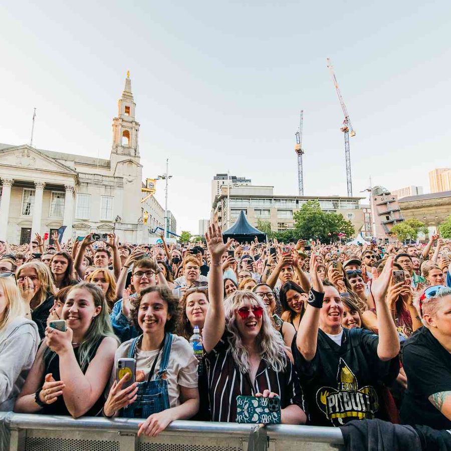 Large crowd gathered in front of outdoor stage during live performance