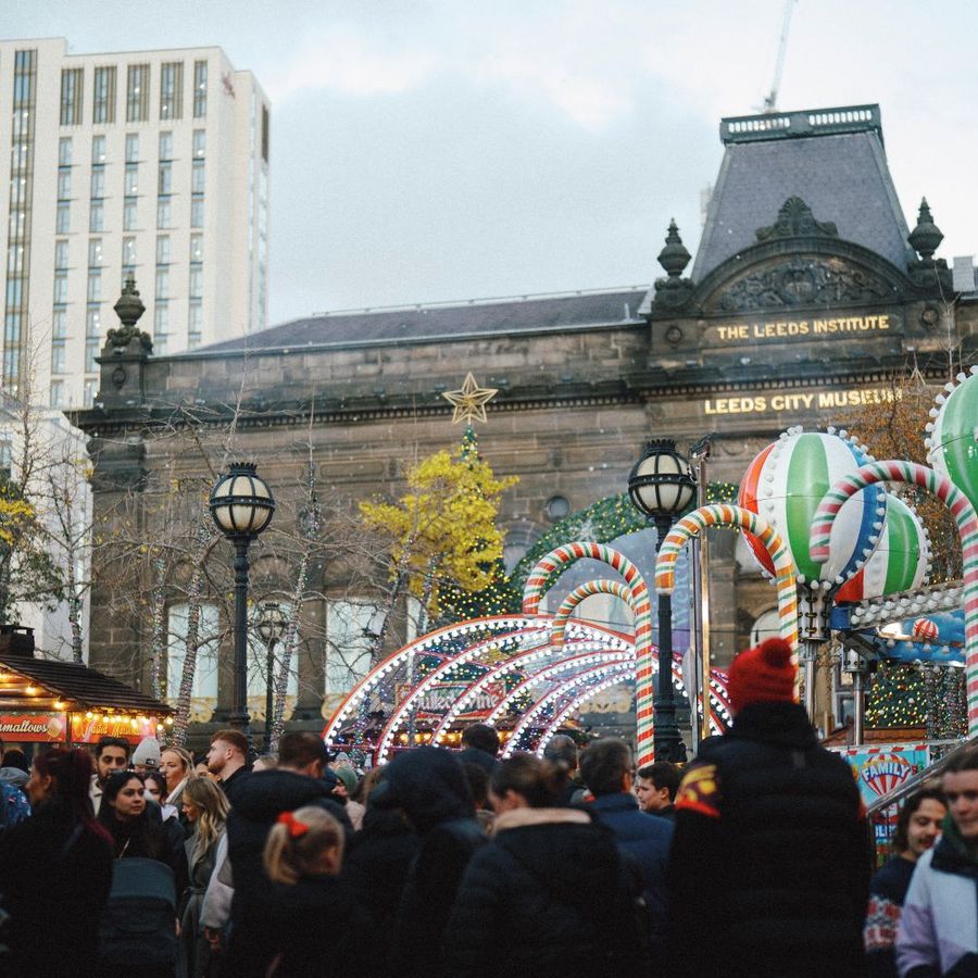 Crowds enjoying festive rides and attractions at Ice Cube Leeds