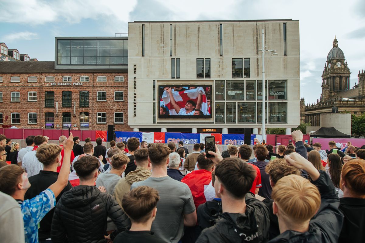 Football supporters watching a live game on the screen